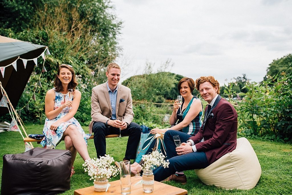 guests relax in the garden on bean bags at garden wedding taken by Parrot & Pineapple Wedding Photography