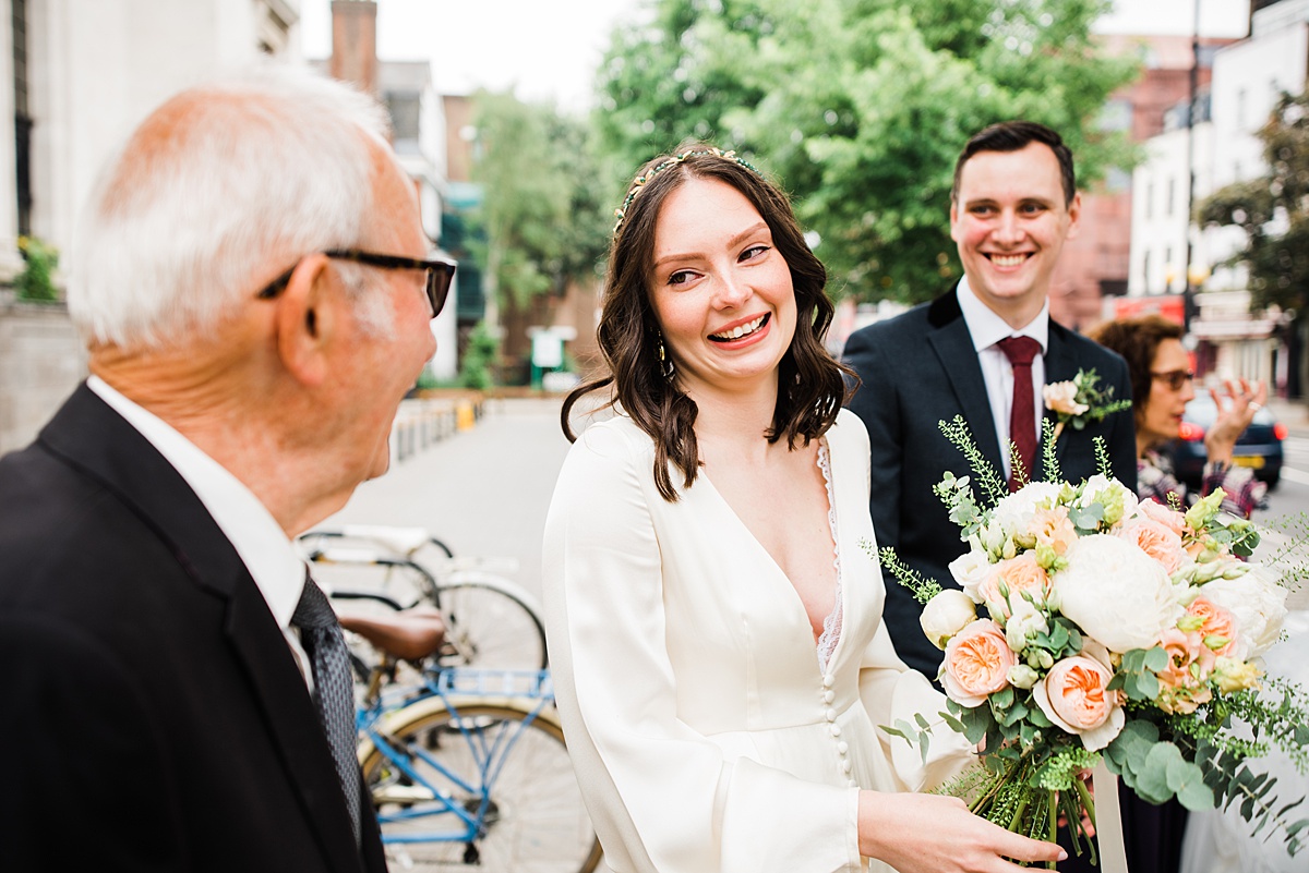 bride smiles at elderly relative outside islington town hall - parrot and pineapple wedding photography