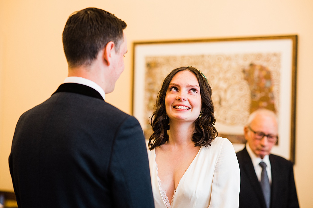 bride smiling upward as they start the ceremony - parrot and pineapple wedding photography