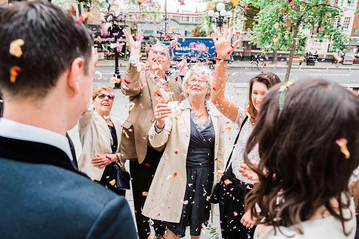 wedding guests throw confetti over bride and groom - parrot and pineapple wedding photography