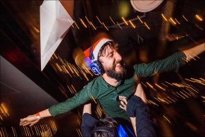 man in green shirt and christmas hat being carried wedding breakfast club party taken by Parrot & Pineapple Wedding Photography
