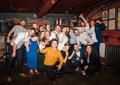 group of friends hug together for group photo at the end of a fun wedding party at Brunswick House.