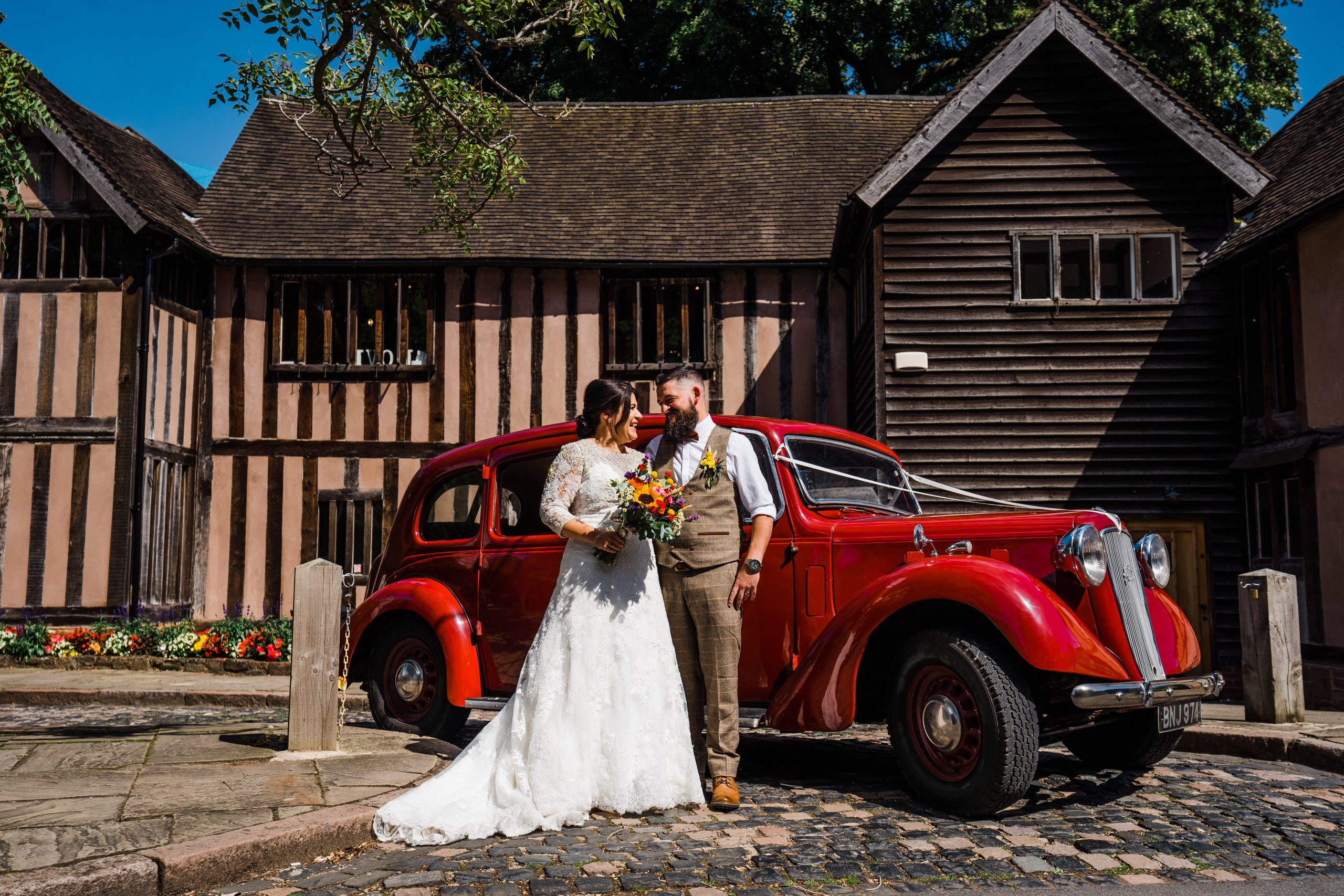 Bride and groom in front of red car Kingstanding-Farm-Wedding