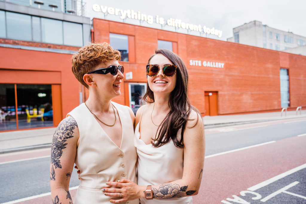 Two brides stand on a street in Sheffield after getting married