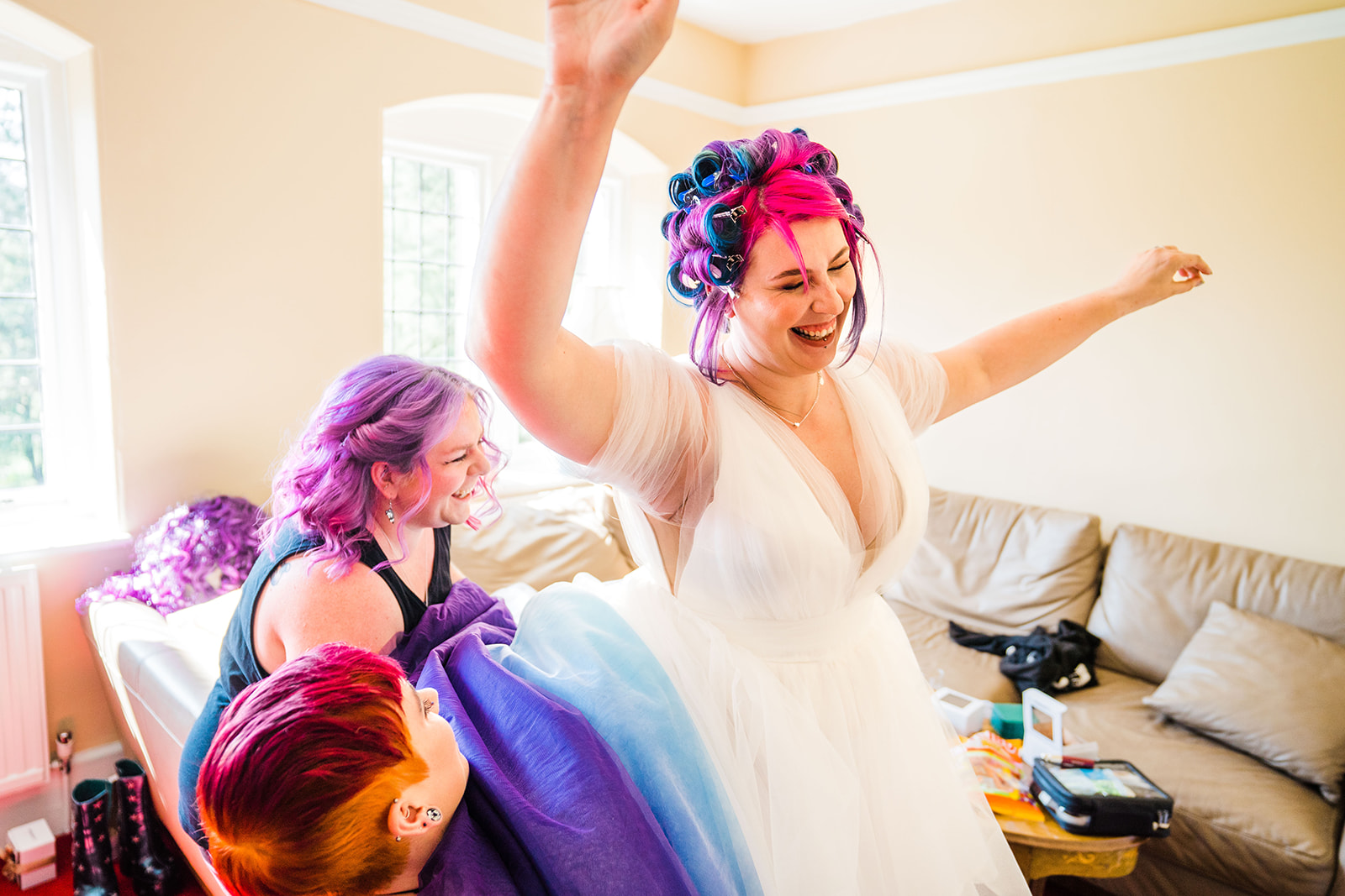 Bride is helped in to her wedding dress by her bridesmaids